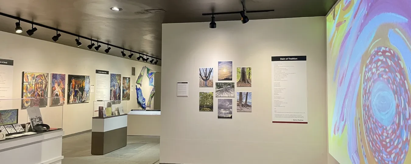 Art gallery interior with colorful paintings, a large abstract display on the right, and soft overhead lighting.