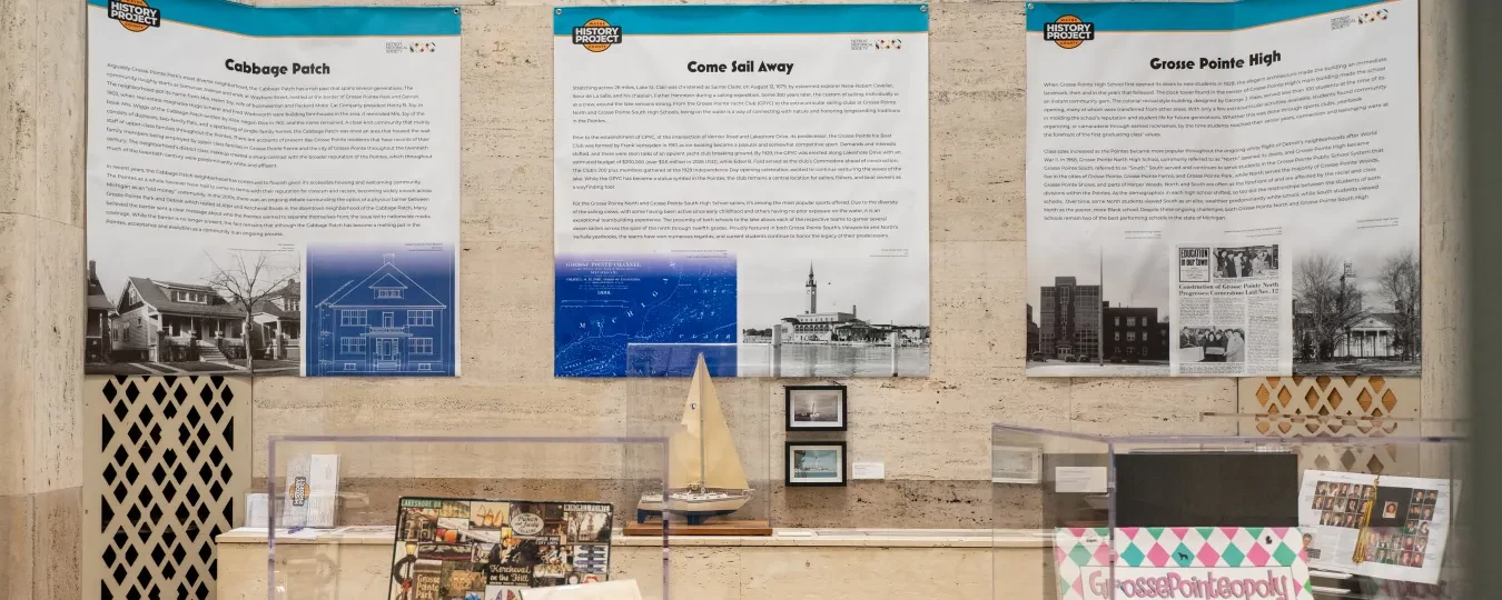 Exhibit room with historical posters on walls, small ship model, and assorted memorabilia on tables.