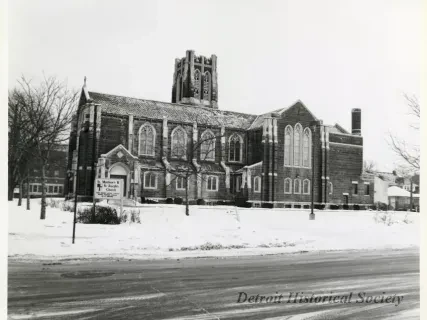 Historic brick church with gothic architecture in a snowy setting.