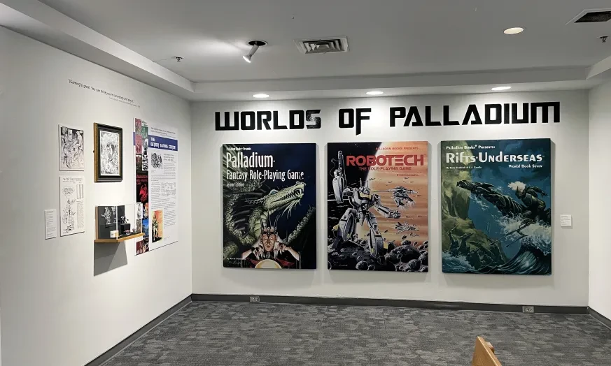 Exhibition wall with "Worlds of Palladium" posters, showcasing sci-fi themes and artwork.