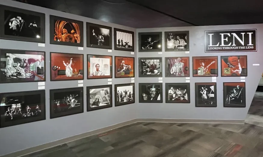 Wall displaying black-and-white and color concert photographs arranged in a gallery setting.