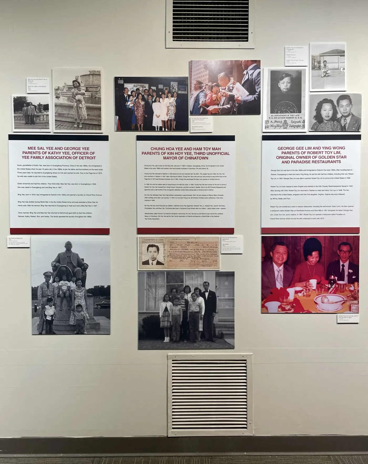 Historical photo exhibit on a wall featuring black-and-white and color photographs with descriptive text panels.
