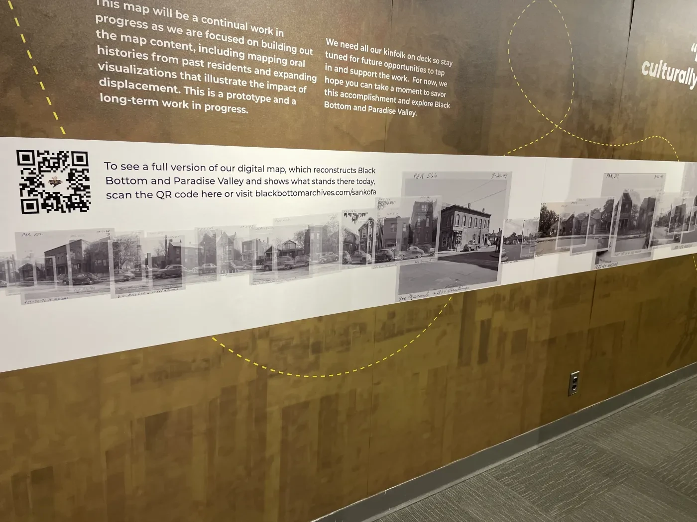 Wall mural with black and white photos of buildings, QR code on the left, brown and white color scheme.