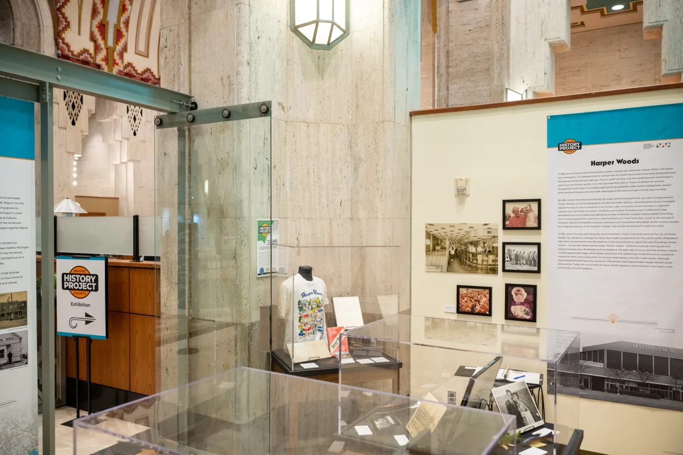 Museum exhibit with informational panels and historical photographs displayed in a glass case.
