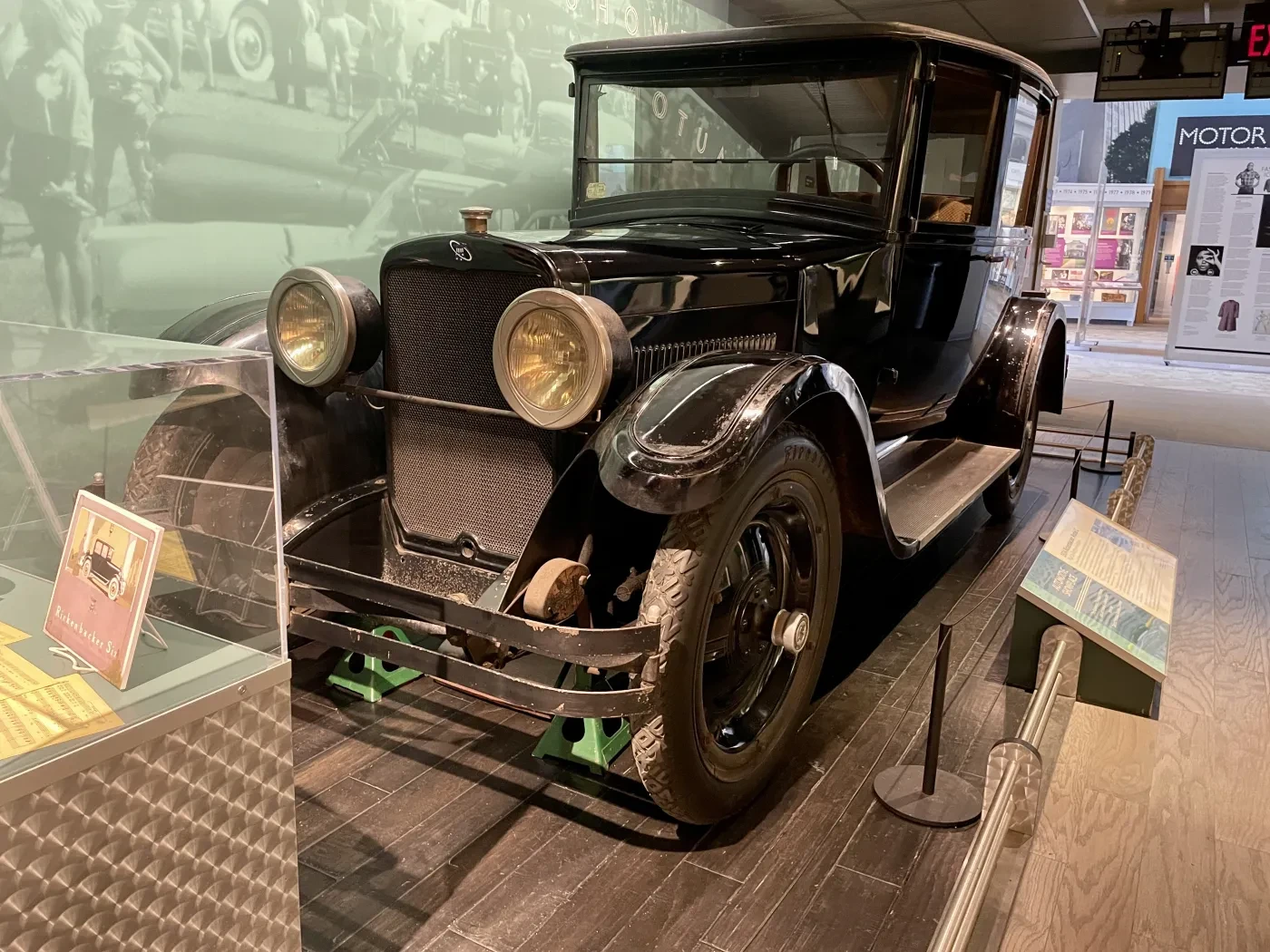 Antique black car displayed in a museum setting.
