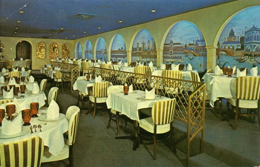 Elegant restaurant with striped chairs, white tablecloths, and large arched windows painted with cityscape murals.