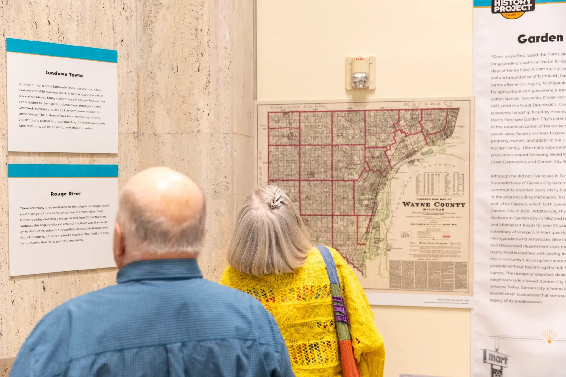 Two people examining a historical map and display in a museum exhibit.